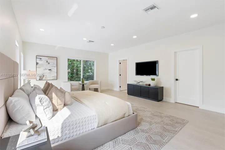 Neutral color palette featuring light-toned wood-finish flooring, recessed ceiling lighting, and solid-core interior doors with matte black hardware