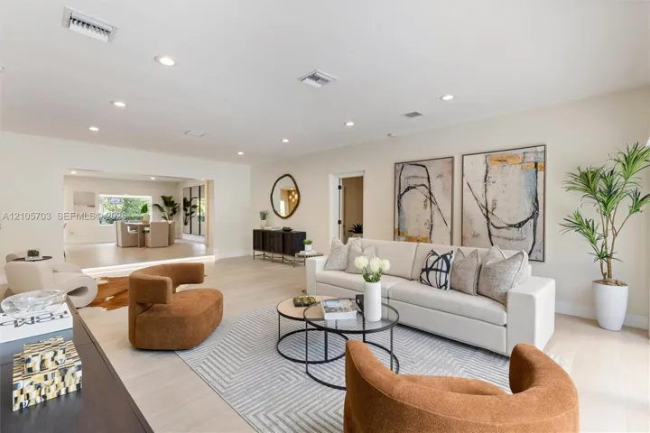 Open-concept room featuring light-toned wood-finish flooring and recessed lighting