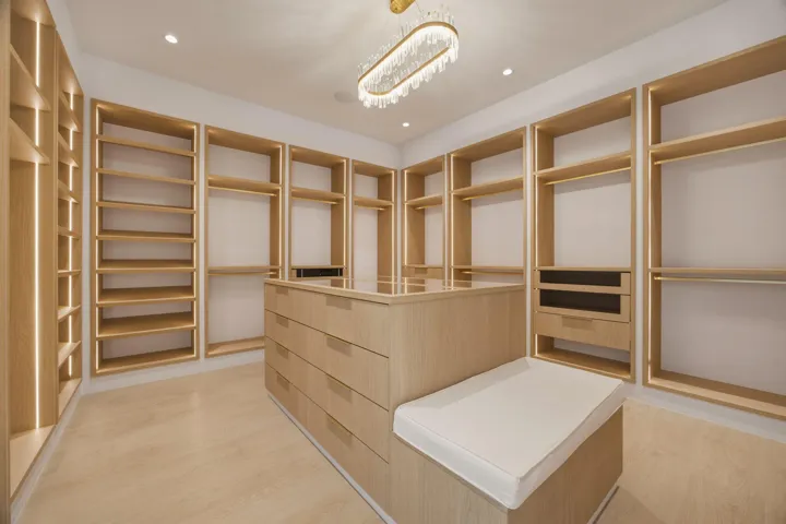 fully built out custom closet with storage bench