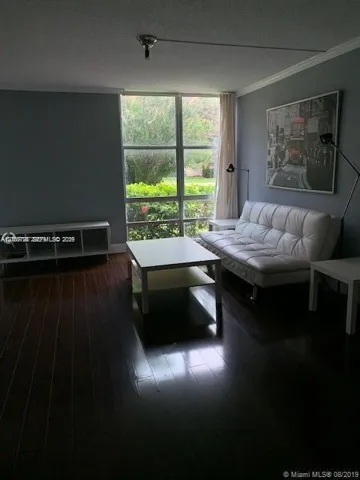 Dark wood-finish flooring, floor-to-ceiling multi-pane window, and crown molding