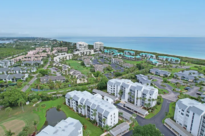 Coastal community featuring multiple residential buildings, green spaces, and a body of water