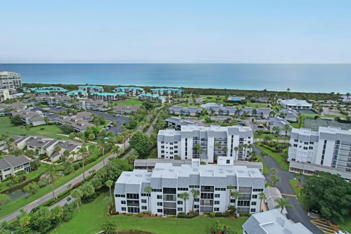 Coastal location with ocean frontage, multiple residential buildings, lush landscaping, and paved access roads