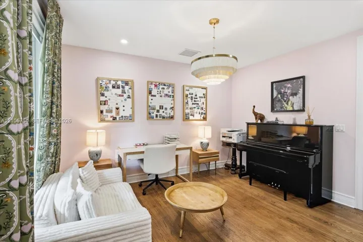 Wood-finish flooring and tiered, brass-accented drum pendant lighting