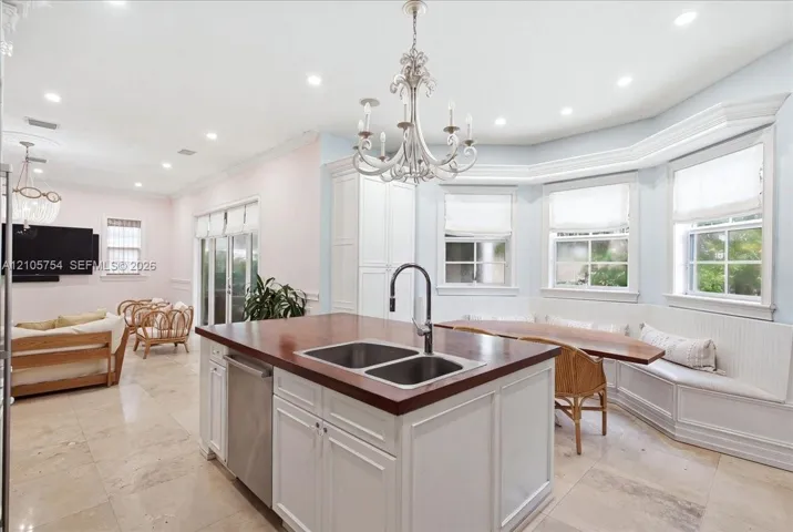 Kitchen island featuring a wood countertop, double-basin stainless steel sink, and gooseneck faucet