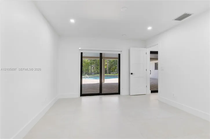 Interior space featuring large-format tile flooring, recessed lighting, and a multi-panel sliding glass door