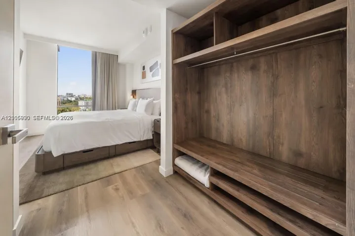 Custom wood-finish built-in shelving, wood-finish flooring, and floor-to-ceiling windows