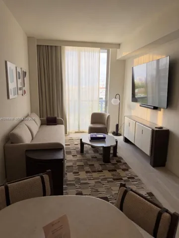 Floor-to-ceiling sliding glass doors, neutral interior palette, and light-toned wood-finish flooring
