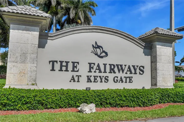 Community signage featuring architectural masonry columns with tile capping, raised lettering, and manicured landscaping