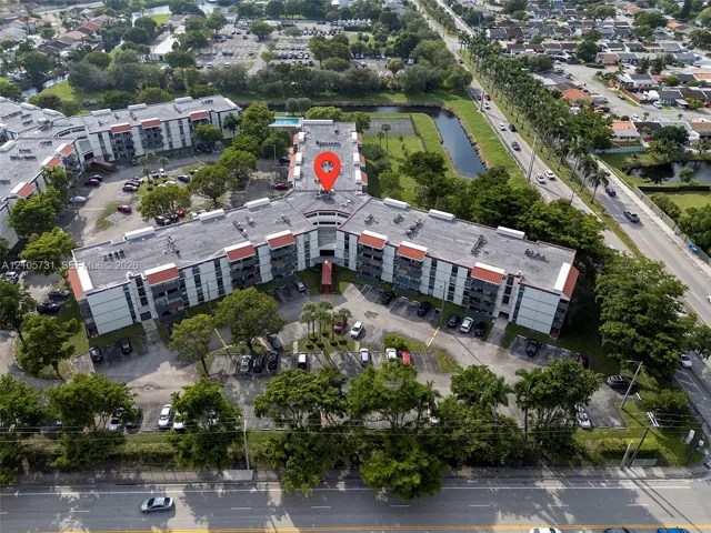 Aerial view of the multi-story complex featuring surface-level parking and mature landscaping