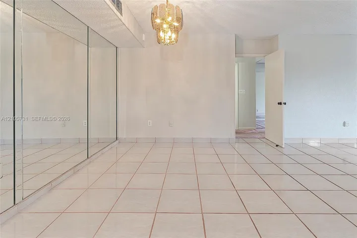 Ceramic tile flooring, full-wall mirrors, and a decorative tiered chandelier