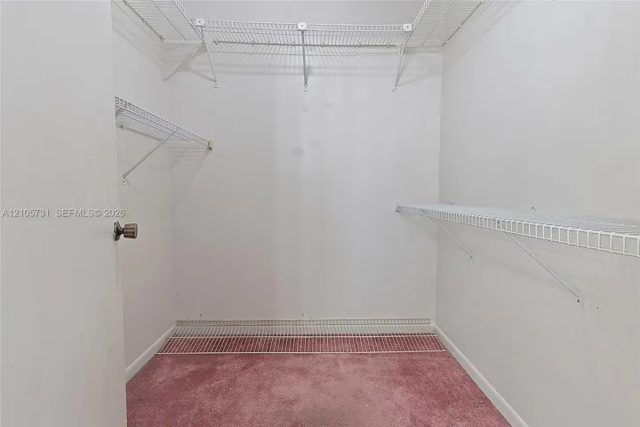 Storage area featuring wall-to-wall carpeting and multi-level white wire shelving
