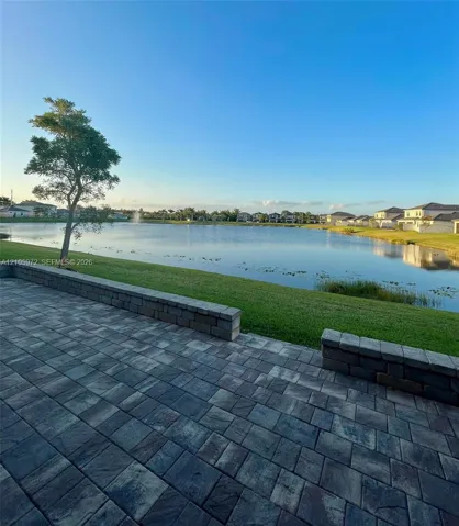 Paver patio featuring integrated stone block seating walls and expansive waterfront exposure