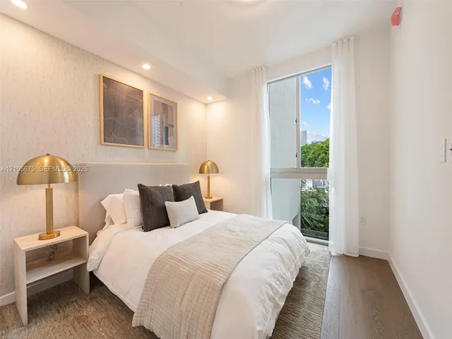 Bedroom featuring wood-finish flooring, textured wall covering, recessed lighting, and a large window with exterior greenery. Images are for finish purposes only. Please refer to the floor plan for the layout.
