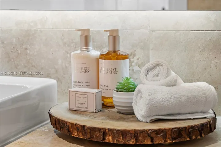 Rectangular white under-mount basin with a natural stone vanity countertop and coordinating polished stone tile backsplash