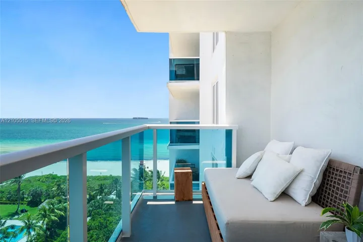 Private balcony featuring a glass-panel railing and concrete flooring, overlooking the ocean