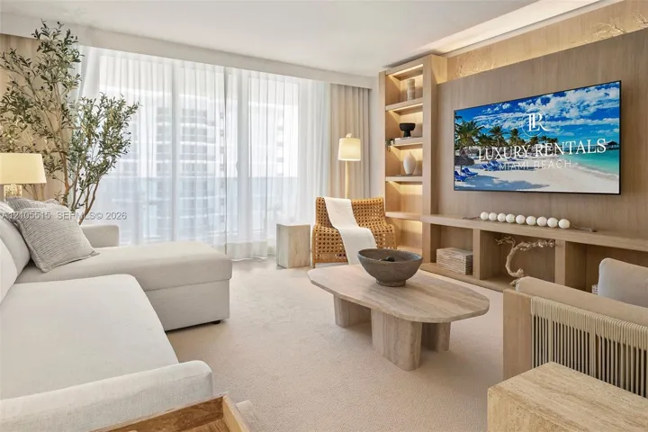 Living area featuring floor-to-ceiling windows, custom built-in wood cabinetry with integrated lighting, and neutral carpeting