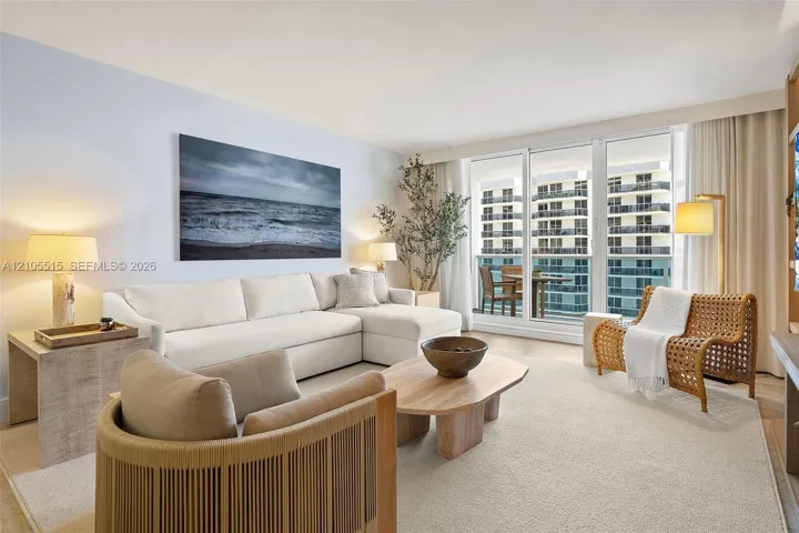Living space featuring floor-to-ceiling glass sliding doors, private balcony access, and light-toned flooring