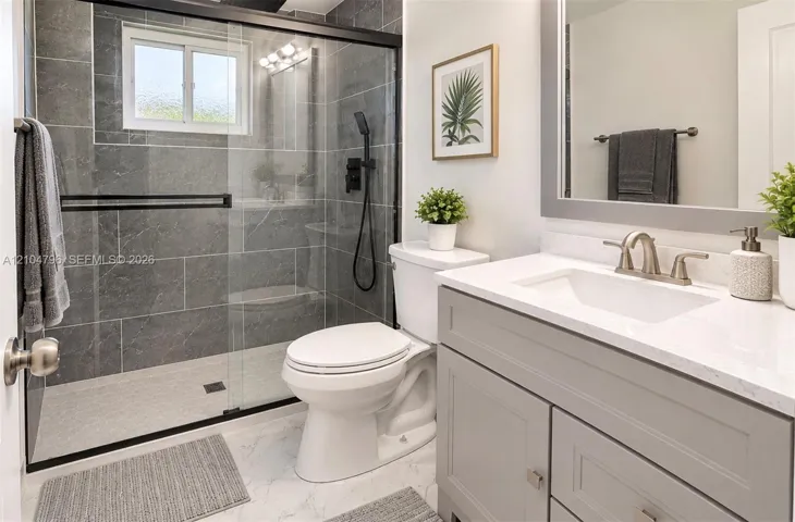 Walk-in shower with floor-to-ceiling tile, sliding glass door, and matte black hardware