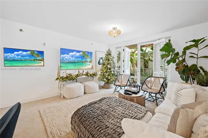 Neutral-toned tile flooring, recessed ceiling lighting, and double glass doors featuring white louvered shutters opening to a private balcony
