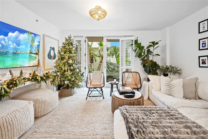 Living area featuring glass-paned double doors, wood-finish flooring, a semi-flush mount rattan light fixture, and white walls