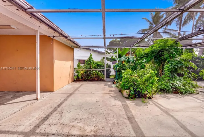 Enclosed patio featuring a concrete floor, metal framing, and mesh screening