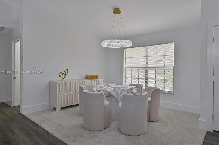 Circular crystal chandelier, multi-pane window, and wood-finish flooring