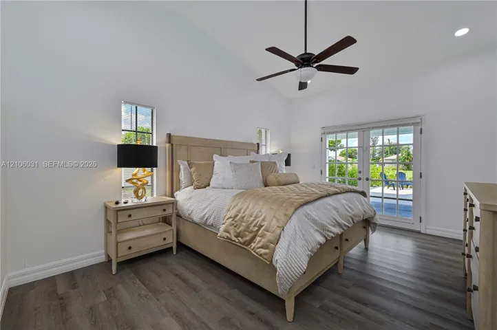 Vaulted ceilings, wood-finish flooring, recessed lighting, ceiling fan, and glass-paneled double doors