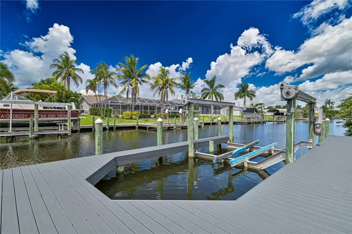 Private boat dock featuring a heavy-duty mechanical boat lift, composite decking, and direct canal access