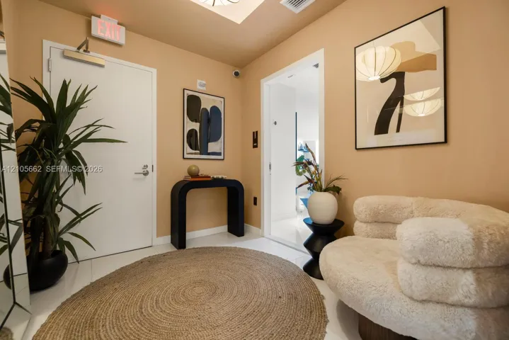 Foyer featuring high-gloss tile flooring, recessed ceiling lighting, and a recessed ceiling architectural detail