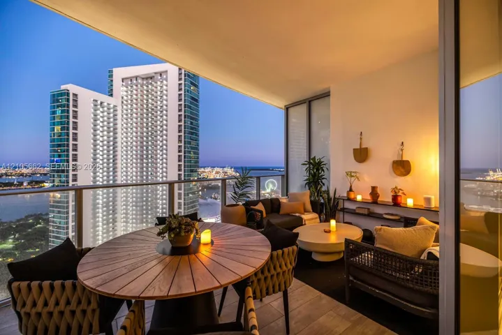 Covered balcony featuring tile flooring and a glass panel railing