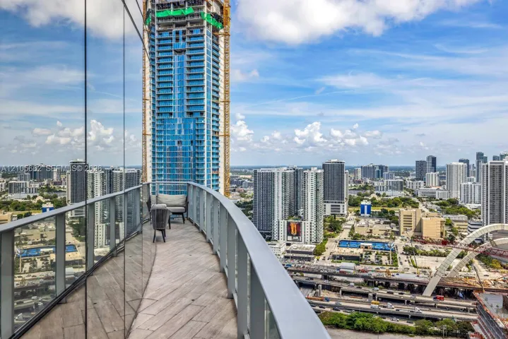 Curved balcony featuring tile flooring and a glass panel railing