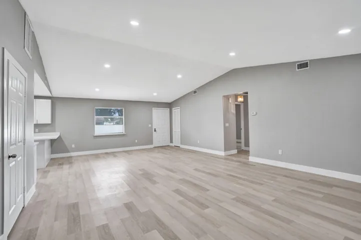 Vaulted ceilings, recessed lighting, and wood-finish flooring