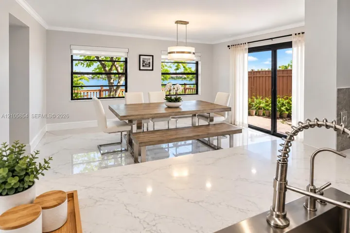 Beautiful dining area viewed from the kitchen, offering stunning lake views and a picturesque setting for everyday dining and entertaining.