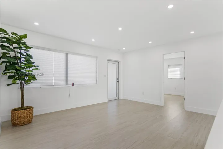Interior room featuring wood-finish flooring, recessed lighting, and a frosted glass exterior door
