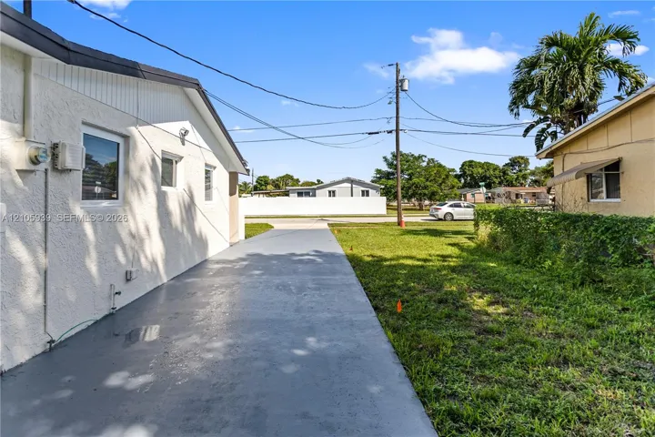 Stucco exterior finish with white paint, single-story profile, and concrete driveway surface