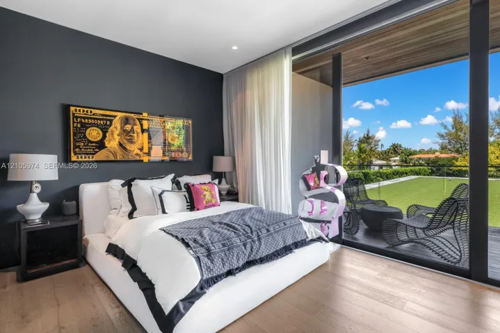 Floor-to-ceiling glass sliding doors, wood-finish flooring, dark-toned accent wall, and a recessed ceiling with wood-plank paneling