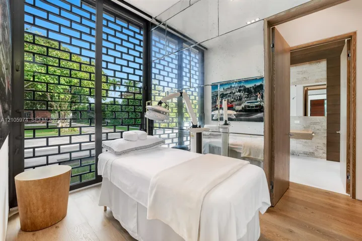 Floor-to-ceiling windows with black metal decorative screening, mirror-panel wall cladding, and wood-finish flooring