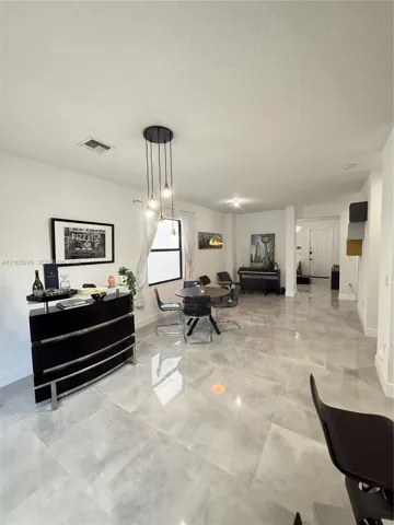 Large-format tile flooring, multi-light pendant fixture, and clean architectural lines
