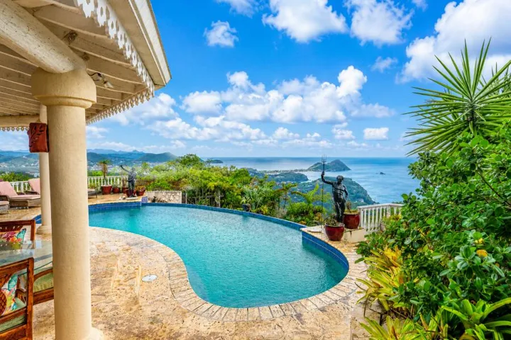 Stunning swimming pool surrounded by tropical landscaping with breathtaking ocean views.