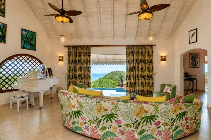 Beautifully furnished living space with vaulted ceilings, colorful tropical décor, and scenic outdoor views.