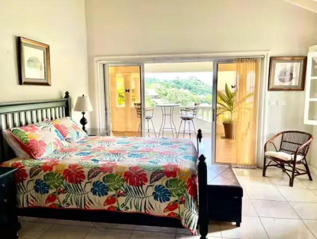 Charming bedroom with colorful bedding and sliding doors overlooking greenery.