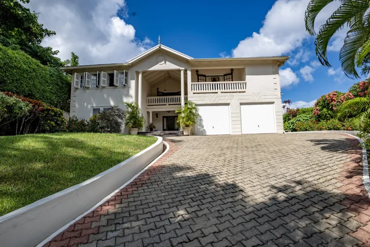 Impressive villa exterior featuring a spacious paved driveway and landscaped grounds.