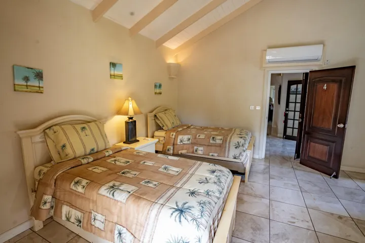 Comfortable bedroom featuring twin beds, vaulted ceilings, and soft lighting.