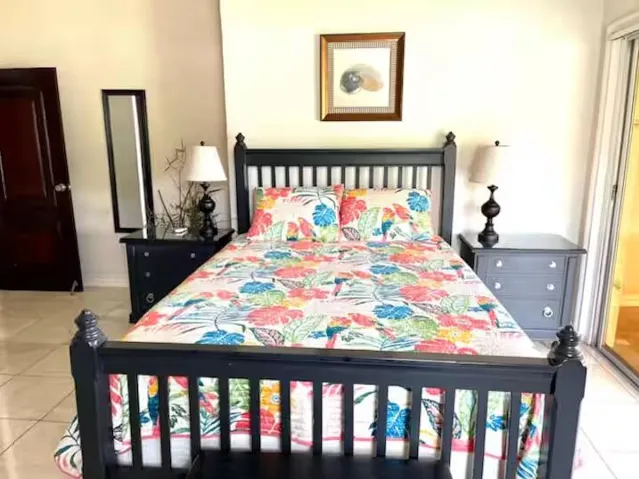 Cozy bedroom featuring vibrant tropical bedding and natural light.