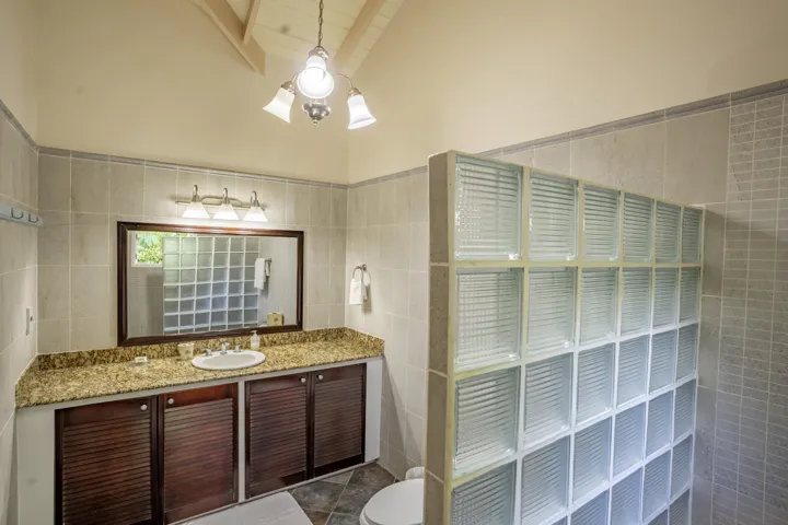 Spacious vanity area featuring granite countertops and built-in open shelving.