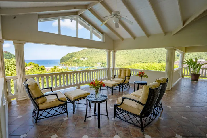 Spacious covered terrace featuring lounge seating and beautiful tropical surroundings.