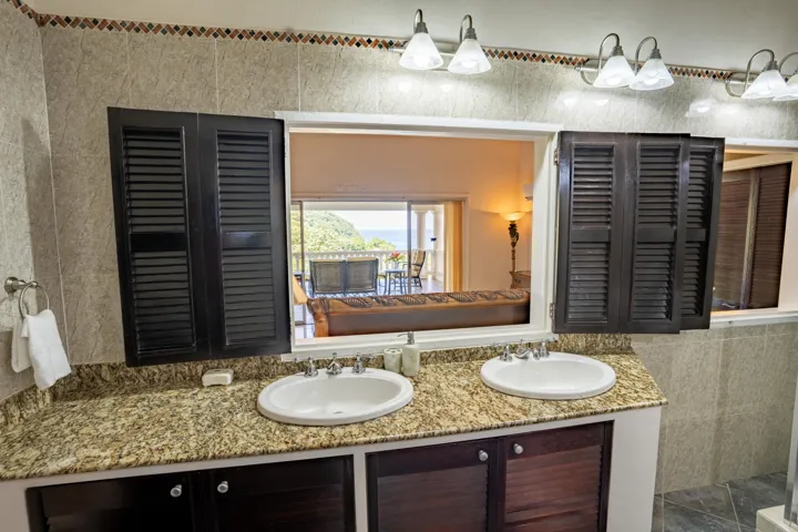 Elegant bathroom with dual sinks, granite countertops, and a large mirror.
