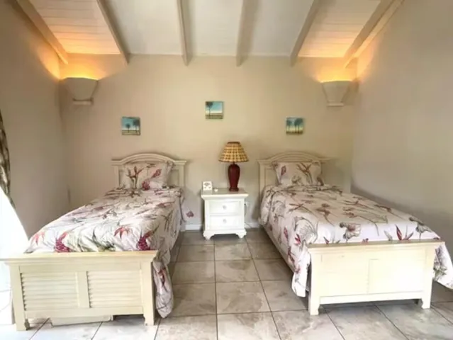 Comfortable bedroom featuring twin beds, vaulted ceilings, and soft lighting.