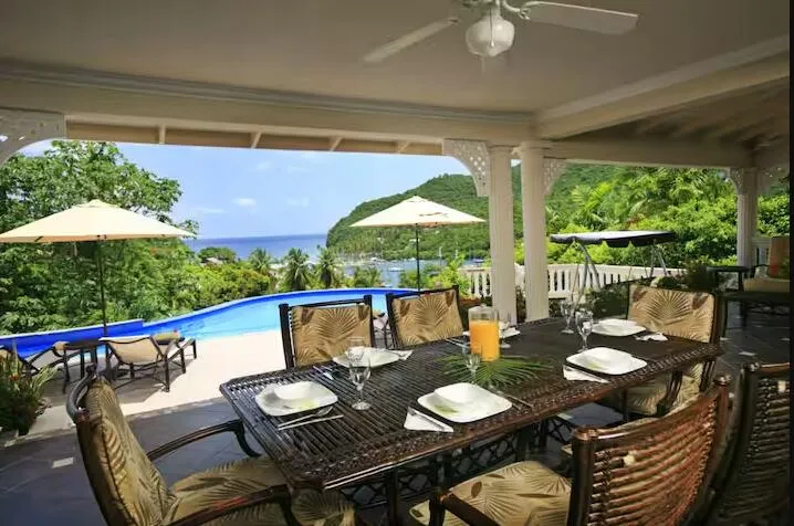 Spacious covered patio featuring comfortable seating and views of the swimming pool.