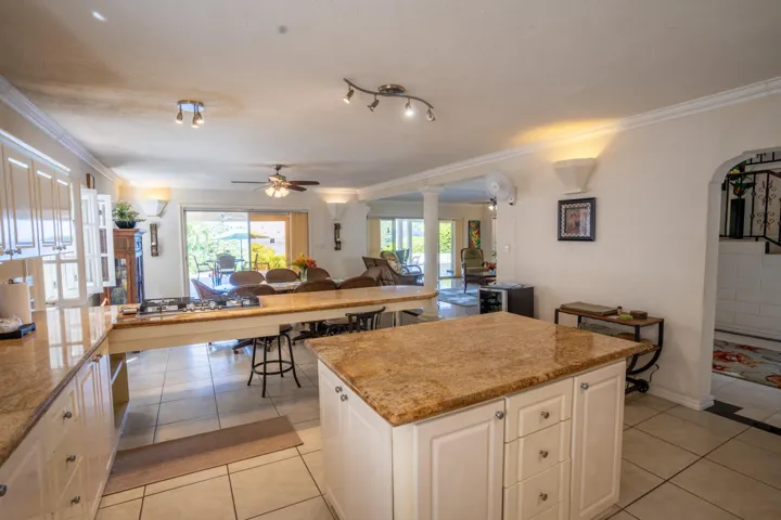Bright kitchen with a central island and adjoining living space.